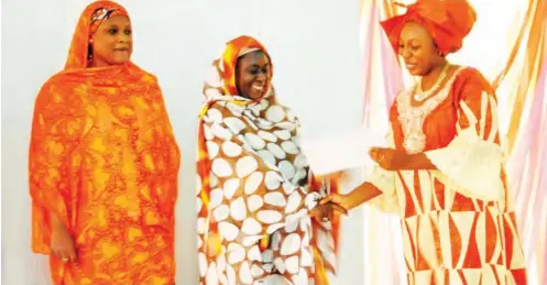  ??  ??  Representa­tive of Jaiz Bank, Hajiya Na’imatu Abdullahi Yakasai (middle), receives an award from Mrs. Lios Alfa, Albe’s, director Multi Concept, at the Kano State Achievers Summit and Award Ceremony in Kano at the weekend. Photo Sani Maikatanga