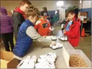  ?? EVAN BRANDT — DIGITAL FIRST MEDIA ?? From left, Cailin and Liam Harrington, from Owen J. Roberts Middle School and their brother Declan from West Vincent Elementary School, joined West Vincent student Jackson Flickinger Monday sorting sneakers for In Ian’s Boots as a way to give back on Martin Luther King Jr. Day.