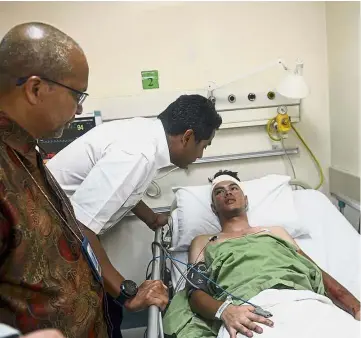  ??  ?? Minor setback: Youth and Sports Minister Khairy Jamaluddin checking on Khairul Nizam Mohd Ali at the Sungai Buloh hospital on Sept 7. — Bernama