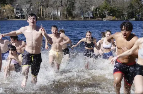  ?? LIBBY O’NEILL — BOSTON HERALD ?? Teens run out of the water during the “Plunge for Elodie” event at Morses Pond in Wellesley on Saturday.