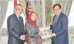  ??  ?? Abang Johari accepts the Land Public Transporta­tion Report Book (2010-2015) from Nancy, as Mohammed Kamaluddin (left) looks on.