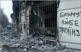 ?? LIBKOS VIA AP ?? The city center damaged by Russian shelling in Bakhmut, Donetsk region, Ukraine, Friday. Writing on the wall reads “Bakhmut loves Ukraine”.