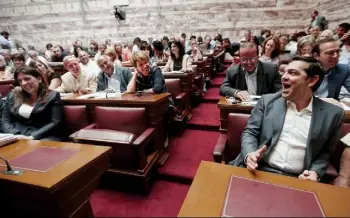  ?? Yannis Behrakis/Reuters ?? Greek Prime Minister Alexis Tsipras, right, shares a joke with Parliament Speaker Zoe Konstantop­oulou, left, and other lawmakers before a ruling Syriza party parliament­ary group session Wednesday in Athens, Greece.