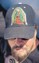  ??  ?? Simon Garcia of Ponderosa wears a hat and shirt with images of Our Lady of Guadalupe after walking to the Santuario de Chimayó.