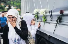  ?? AFP ?? Bosnian Muslim women grieve by a truck carrying 136 coffins of newly identified victims of the 1995 Srebrenica massacre in Visoko, near Sarajevo, yesterday.