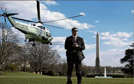  ?? — Bloomberg ?? Up in the air: A member of the US Secret Service standing guard as Marine One, with Trump on board, departs the South Lawn of the White House in Washington, DC.