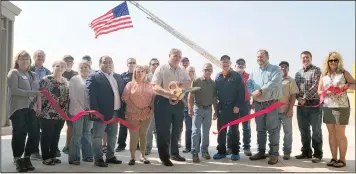  ?? HERALD photo/roger Cline ?? Big Spring Mayor Shannon Thomason, center, cuts a red ribbon Friday, thus declaring the city’s new Big Sandy Landfill open for business.