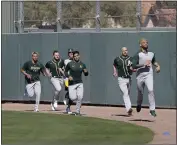  ??  ?? The A’s Sean Manaea, front, leads a group of pitchers during spring training practice on Thursday in Mesa, Ariz.