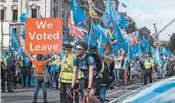  ?? VUDI XHYMSHITI/AP ?? A Brexit supporter holds up a sign near opposition protesters Tuesday at Parliament Square in London.