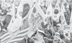  ?? — Gambar Yonhap/Reuters ?? TETAP SOKONG: Penyokong Park berhimpun di luar mahkamah selepas pendakwa raya memohon hukuman penjara selama 30 tahun terhadap bekas presiden itu di Seoul, semalam.