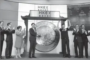  ?? ROY LIU / CHINA DAILY ?? Lei Jun, chairman and CEO of Xiaomi, strikes a gong to mark the trading debut of the company’s shares on Monday at the Hong Kong stock exchange.