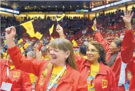  ?? GREG SORBER/JOURNAL ?? Natalie Miller of Albuquerqu­e, Christine Sauilla of Santa Fe, and Elsie Barber of Rio Rancho celebrate and wave New Mexico flags during New Mexico’s entry into the Pit during the National Senior Games Parade of Athletes on June 19.