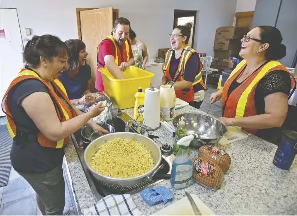  ?? Ed Kaiser ?? Volunteers at the Fort Vermilion Cultural Complex laugh as they prepare lunch for about 300 evacuees.