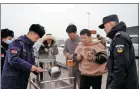  ?? PHOTOS PROVIDED TO CHINA DAILY ?? Right: Police officers provide free food for stranded travelers at a security checkpoint in Guazhou last month.