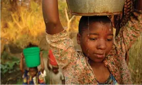  ?? Photograph: Helen H Richardson/ Denver Post via Getty Images ?? A teenager in Malawi hauls a bucket of water before school. Women in poor countries spend hours carrying water home from distant sources.