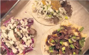  ?? LAUREN DELGADO/ORLANDO SENTINEL ?? Tacos at BTW in Tavares get filled with ingredient­s such as macaroni and cheese to blackened mahi-mahi. Pictured here are the (from left) WTF (What the Fish) with mahi-mahi, the Korean barbecue bulgogi pork and the YOLO taco.