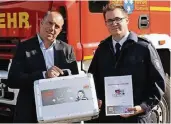  ?? FOTO: STADT VIERSEN ?? Claus C. Braunen (Provinzial) übergab den Brandschut­zkoffer an Simon Fritsch von der Feuerwehr Viersen.