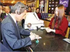  ?? EMMANUEL DUNAND/AFP ?? Japanese Prime Minister Junichiro Koizumi (left) signs a credit card receipt on March 21, 2002. The antiquated way of verifying identity looks to be on the way out.