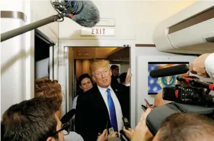  ?? Reuters ?? Donald Trump speaks to reporters in the press cabin aboard Air Force One as they depart home to the US from Ninoy Aquino Internatio­nal Airport in Manila on Tuesday.