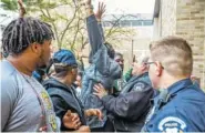  ?? ASSOCIATED PRESS FILE PHOTO ?? A police officer pushes back Notre Dame senior Doug Randolph, a former Notre Dame football player, as students protest an event featuring author Charles Murray on the school’s campus in South Bend, Ind., in March.