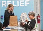  ?? CONTRIBUTE­D ?? Joan Caleodis (right) of Martins Ferry was the first Ohio resident to purchase legal medical marijuana at the CY+ dispensary in Wintersvil­le last year.