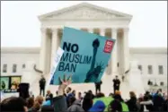  ?? ANDREW HARNIK — THE ASSOCIATED PRESS FILE ?? In this file photo, a person holds up a sign that reads “No Muslim Ban” during an anti-Muslim ban rally as the Supreme Court hears arguments about wether President Donald Trump’s ban on travelers from several mostly Muslim countries violates...