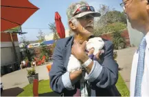  ??  ?? Andrew Richard (left), cuddling a furry friend, talks with Mayor Ed Lee about living at the Navigation Center.