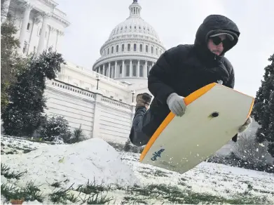  ?? Picture: AFP ?? A man rides a sled by the US Capitol in Washington, DC. The metro region received between 5cm and 10cm of snow earlier this week.