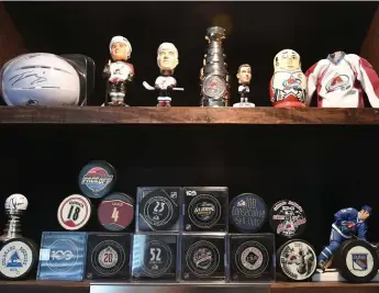  ?? RJ Sangosti, The Denver Post ?? Jake Dubin’s hockey collection includes pucks, bobblehead­s and figurines.