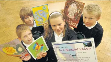  ??  ?? ●●Rebecca Swaine with her winning entry for the Fair Trade competitio­n (centre) with highly commended pupils Declan Burleigh, Kyle Brown and Jack Simpson