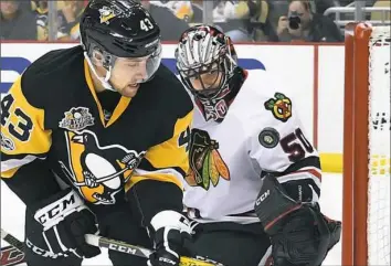  ??  ?? Conor Sheary eyes a shot against Chicago Blackhawks goalie Corey Crawford on Wednesday.