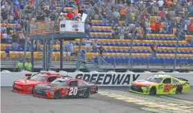  ?? THE ASSOCIATED PRESS ?? Justin Allgaier and Christophe­r Bell run side by side on a white-flag restart with Brandon Jones right behind during the NASCAR Xfinity Series race Saturday at Iowa Speedway in Newton, Iowa. Bell won the race and Allgaier finished second.