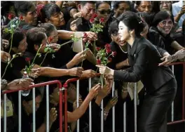  ?? AFP ?? STILL POPULAR Former Thai Prime Minister Yingluck Shinawatra receives roses from supporters as she arrives at the Supreme Court in Bangkok for a hearing of the negligence charges for which she was ousted in 2014.—