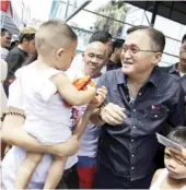  ?? PHOTOGRAPH COURTESY OF SBG ?? A TODDLER carried by her mom catches the attention of Senator ‘Bong’ Go during his visit to fire victims in Manila to help them rebuild their lives.