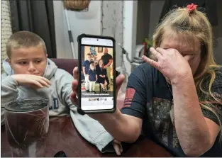  ?? MAX BECHERER — VIA THE ASSOCIATED PRESS ?? Darra Ann Morales shows a photo of her son Chaz Morales and his family on her phone as Chaz Jr., 10, comforts his grandmothe­r at their home in Slidell, La., on Wednesday. Chaz Morales is one of the crew members missing from the capsized vessel Seacor Power.