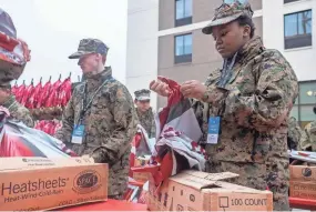  ?? ?? Members of the Marine Corps JROTC out of Horn Lake hand out blankets to finishers of the 5k during the St. Jude Memphis Marathon weekend in 2019.