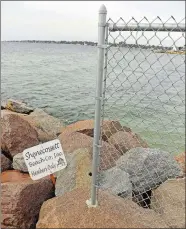  ?? SEAN D. ELLIOT/THE DAY ?? A chain-link fence and sign Wednesday atop the jetty between the University of Connecticu­t’s Avery Point beach and the Shenecosse­tt Beach Club in Groton.