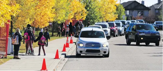  ?? GAVIN YOUNG ?? Parents line up in vehicles to pick up students at New Brighton Elementary School on Monday afternoon. The Calgary parking authority is targeting drivers who break the law.