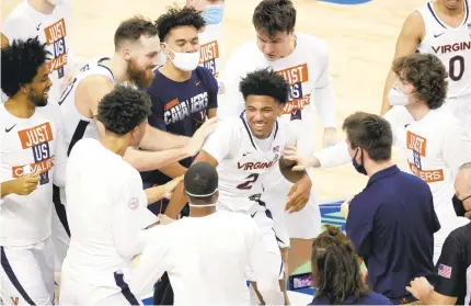  ?? JARED C. TILTON/GETTY IMAGES ?? Virginia freshman guard Reece Beekman, center, celebrates with teammates after hitting a game-winning 3-pointer as time expired in an ACC quarterfin­al against Syracuse on Thursday in Greensboro, North Carolina. It was his only points of the game.