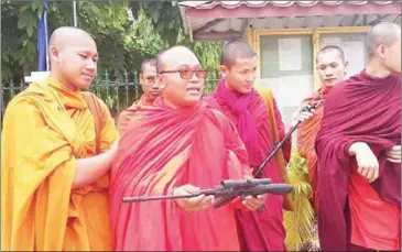  ?? FACEBOOK ?? Monk But Buntenh (centre) displays a toy gun during a protest for the release of fellow monk Horn Sophanny, who was arrested on weapons charges after allegedly posing for a photo with the fake rifle.