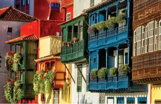  ??  ?? En haut, la côte rocheuse sur le camino del Poris, à Tijarafe, sur le versant ouest de l’île. Ci-dessus, dans le centre historique de Santa Cruz de La Palma, façades colorées et balcons en bois façonnés.