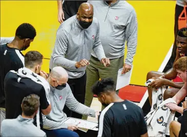  ?? WILFREDO LEE/ASSOCIATED PRESS ?? Something has connected, at least short-term, for the Hawks under interim coach Nate Mcmillan (center), shown here making a point during a timeout. The Hawks are 3-0 this month.