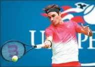  ?? MATTHEW STOCKMAN / GETTY IMAGES / AFP ?? Roger Federer returns a shot against Mikhail Youzhny during their second-round match of the US Open on Thursday. Federer won 1-6, 7-6 (3), 6-4, 4-6, 6-2.