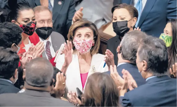  ?? J. SCOTT APPLEWHITE/AP ?? Speaker Nancy Pelosi, center, celebrates with Democratic lawmakers on Friday after the House voted.