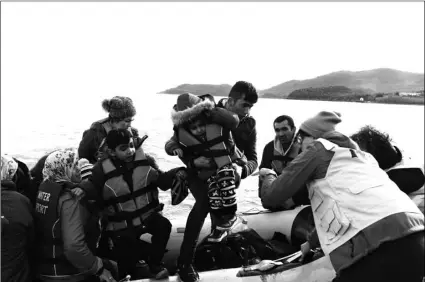  ?? AP PHOTO/MICHEAL VARAKLAS ?? Refugees and migrants arrive with a dinghy at the village of Skala Sikaminias, on the Greek island of Lesbos, after crossing the Aegean sea from Turkey, on Friday.