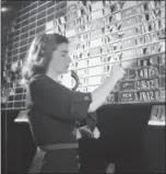  ?? AP PHOTO/DAN GROSSI, FILE ?? Dolores Hennessy, bulletin clerk in the quotation department, changes bid and asked prices on the informatio­n relayed to her from the central tube room in New York on Sept. 6, 1947. The lettered cards carry symbols for Curb Exchange stock issues while the numbered cards show the current market in those issues.