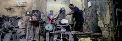  ?? — AFP ?? Egyptian craftsmen make water pipes at a workshop in the Qaitbay district in old Cairo. The water pipes, also known as shishahs, are stacked and packed for shipping, some to far corners of the world.