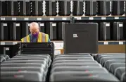 ?? GERRY BROOME / ASSOCIATED PRESS ?? A worker prepares tabulators Thursday for the upcoming election at the Wake County Board of Elections in Raleigh, N.C.
