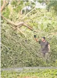  ?? JACK GRUBER, USA TODAY ?? Residents worked to clear trees and debris closing off neighborho­ods in Coral Gables, southwest of Miami.