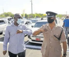  ??  ?? With taxis and their operators in the background, Mayor of Portmore Leon Thomas (left) and head of the St Catherine South Police Division Senior Superinten­dent Clive Blair elbow bump each other inside the Portmore Mall Transporta­tion Centre in St Catherine last month, after the facility was officially opened. The acting head of the Transport Authority says he will be educating the public so that they can understand their role in how public transporta­tion systems shoud operate.